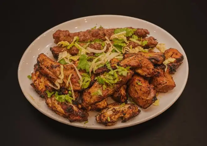 Traditional Lahori chargha and karahi dishes served on a table in London