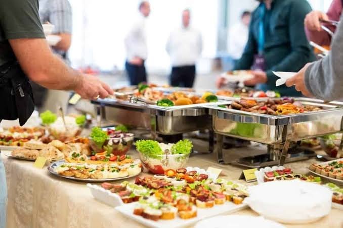 Office team receiving corporate catering delivery for a large event.