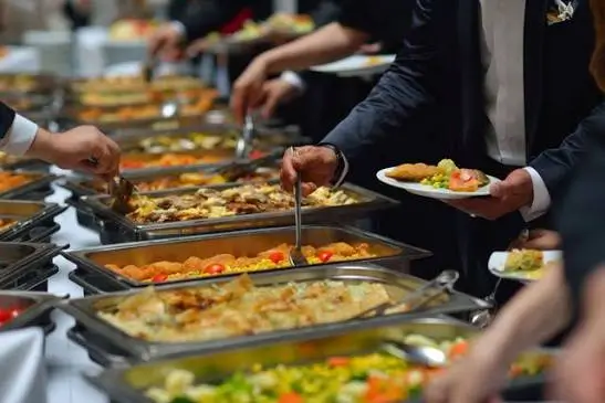 Professionally set corporate catering buffet with labelled halal and vegetarian dishes at a business conference
