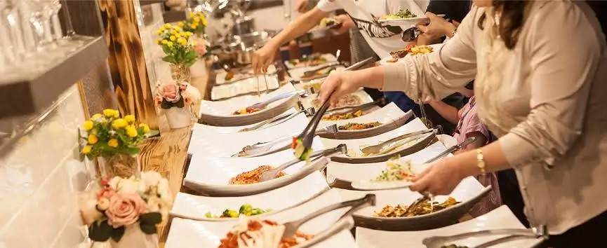 Catering service for family gatherings with a buffet of biryani, kebabs and desserts set up in a community hall