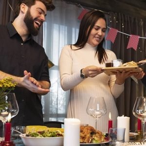 A man and woman stand at a table with food, showcasing private event catering by Taste of Lahore Events.